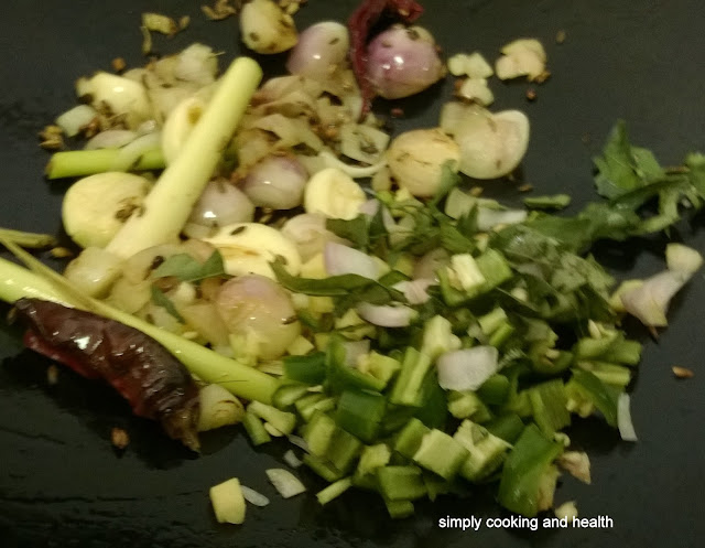 Adding lemon grass, pandan leaf, green chili and curry leaves