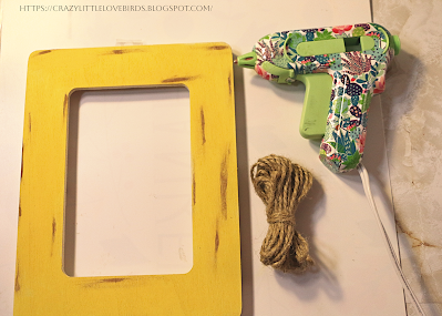 Yellow picture frame, twine and hot glue on a table