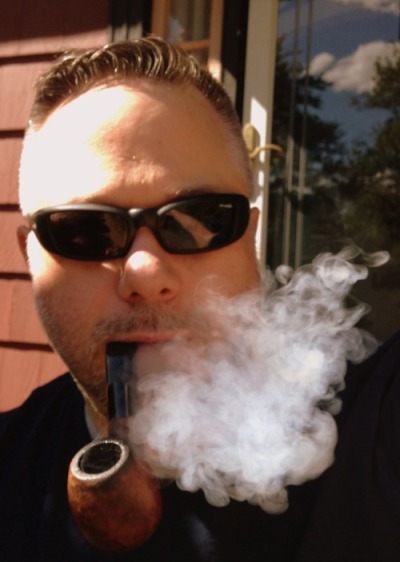 Handsome pipe smoker wearing sunglasses from the neck up
