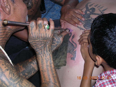 A Thai devotee shows off his elaborate tattoos all over his chest during the