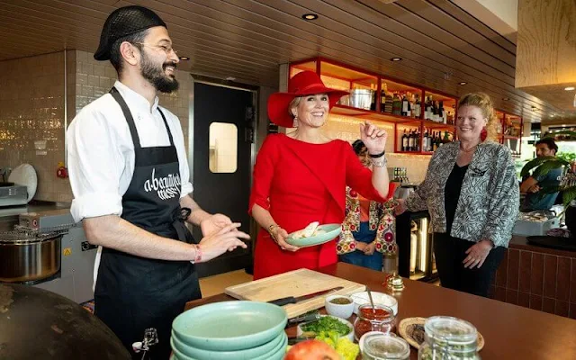 Queen Maxima wore a red dress and cape by Natan. A Beautiful Mess restaurants are an initiative of the Refugee Company