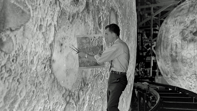 Photo showing a model maker designing a scale replication of the Moon surface.