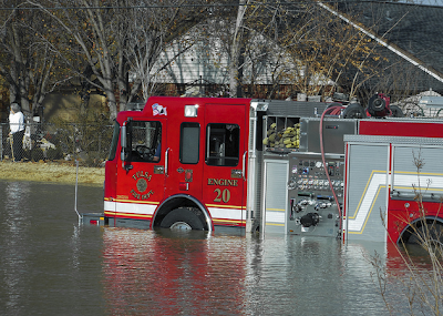 Photo of a red Tulsa firetruck sitting on a flooded street in Tulsa, Oklahoma due to a water main break