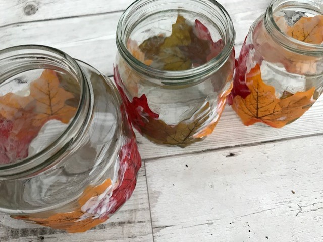 3 jars with leaves glued to them