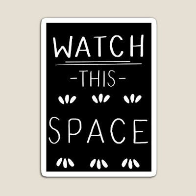 Fridge magnet showing watch this space in white hand-lettered text on a black background.