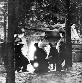 German soldiers around a campfire beside a Panther tank, somewhere in the Ardennes, Belgium,1944-1945 .