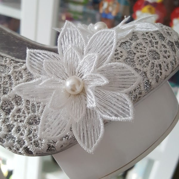 close up of pearl and flower detail on front of shoe and silver glitter under lace uppers