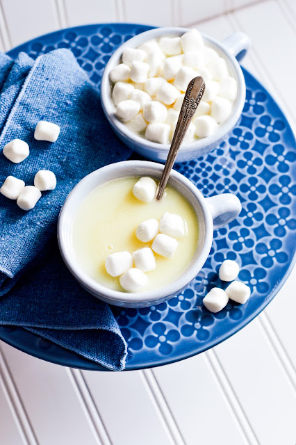hot chocolate in white mug with marshmallows and a spoon.