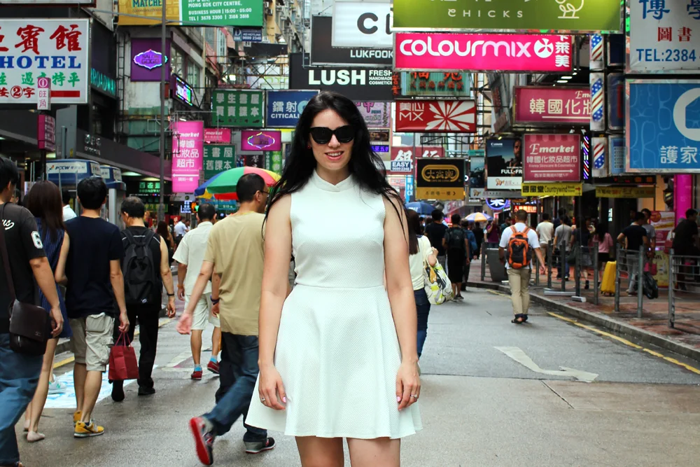 Fashion blogger Emma Louise Layla in white Dorothy Perkins dress on a busy Hong Kong street