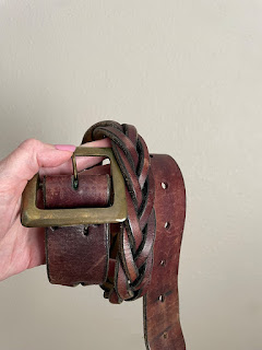 A leather belt held in a hand