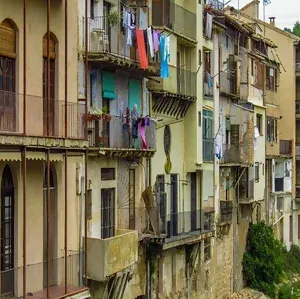 Foto imagem de parte de um condominio, mostrando janelas e sacadas com roupas penduradas e secando.