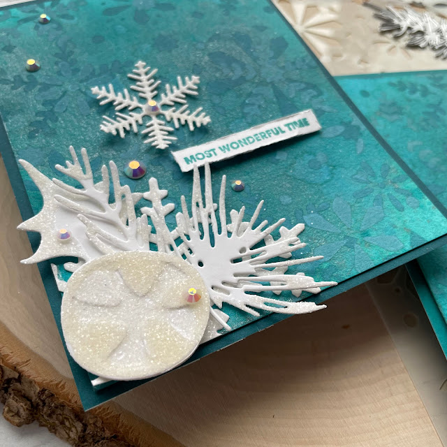 Winter Wonderland Holiday Cards made with: Tim Holtz modern festive die, rock candy distress glitter, distress spray stain, distress oxide, distress mica stain; Scrapbook.com solar white cardstock, wordfetti fa la la stamp, peppermint winter stencil, cools jewels smooth cardstock; Pinkfresh jewels; Pima watercolor paper