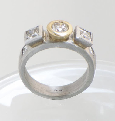 custom platinum engagement ring with diamonds in a yellow gold bezel