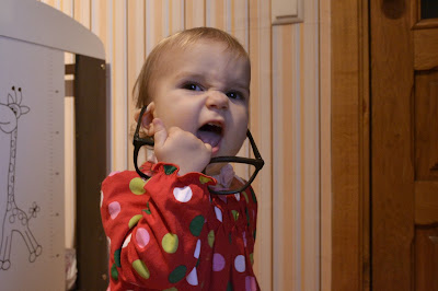 small girl taking off big black sunglasses and smiling, laughing