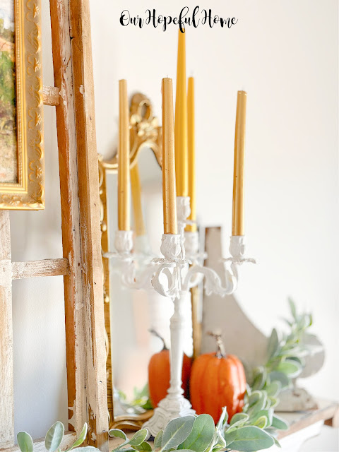 white candelabra with gold taper candles on mantel