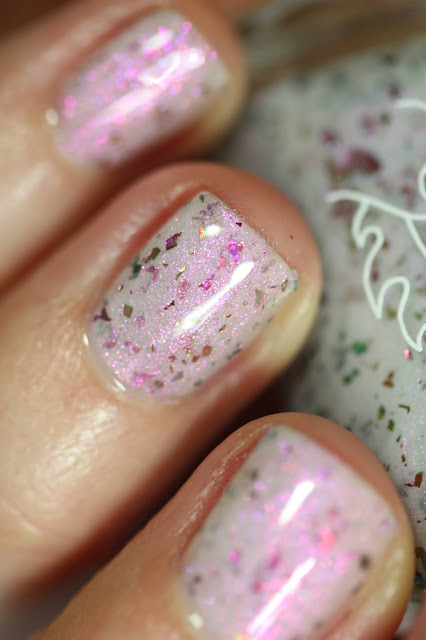 white crelly with magenta shimmer swatched on white person's nails