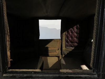 dark interior of landau with red cushioning on wall