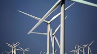 The image shows a group of windmills against a blue sky. Windmills are devices that convert wind energy into electrical energy. They are a source of renewable energy that does not pollute the environment.