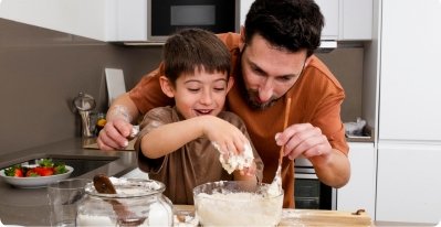A boy enjoying baking with his dad