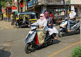 masked women riding a scooter in Pune