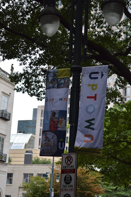 Flags on a tree letting people know they are in a part of the city called uptown.