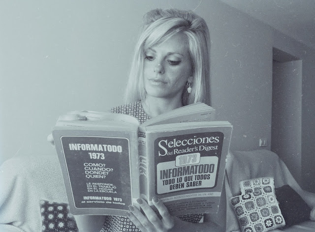 Alejandra Colomera leyendo un libro original del año 1973, llamado Informatodo de Reader's digest. La imagen está en blanco y negro
