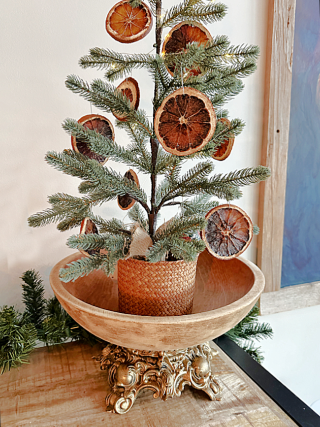 tree with oranges in wooden bowl and stand