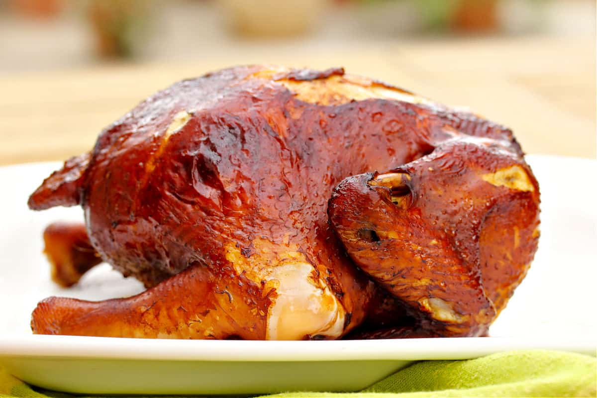 whole crispy soy chicken on a white tray.