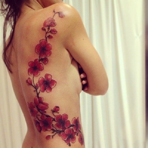 Uma bela cadeia de flores de cerejeira em tatuagem. As flores de cerejeira estão lindamente coloridas em tons de vermelho, enquanto os ramos lentamente fina e quase desaparece dando a ilusão de que as flores de cerejeira são magicamente para cima, agarrando-se a pessoa de volta. (Foto: Fontes de imagem)