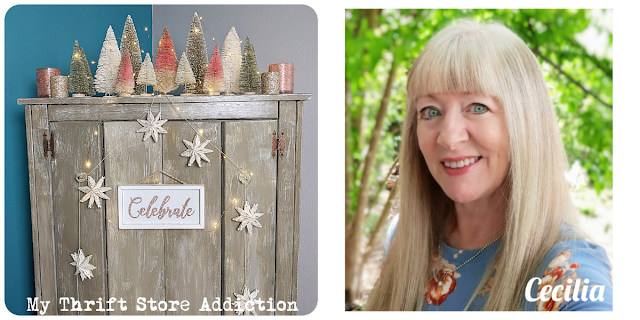 wooden armoire with bottle brush trees and snowflake garland