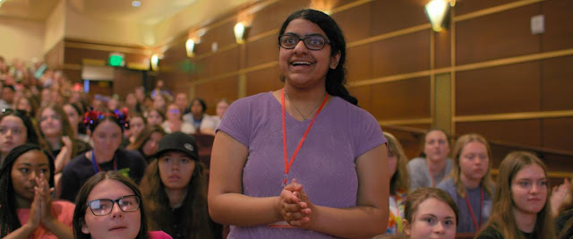 A girl stands up in an audience