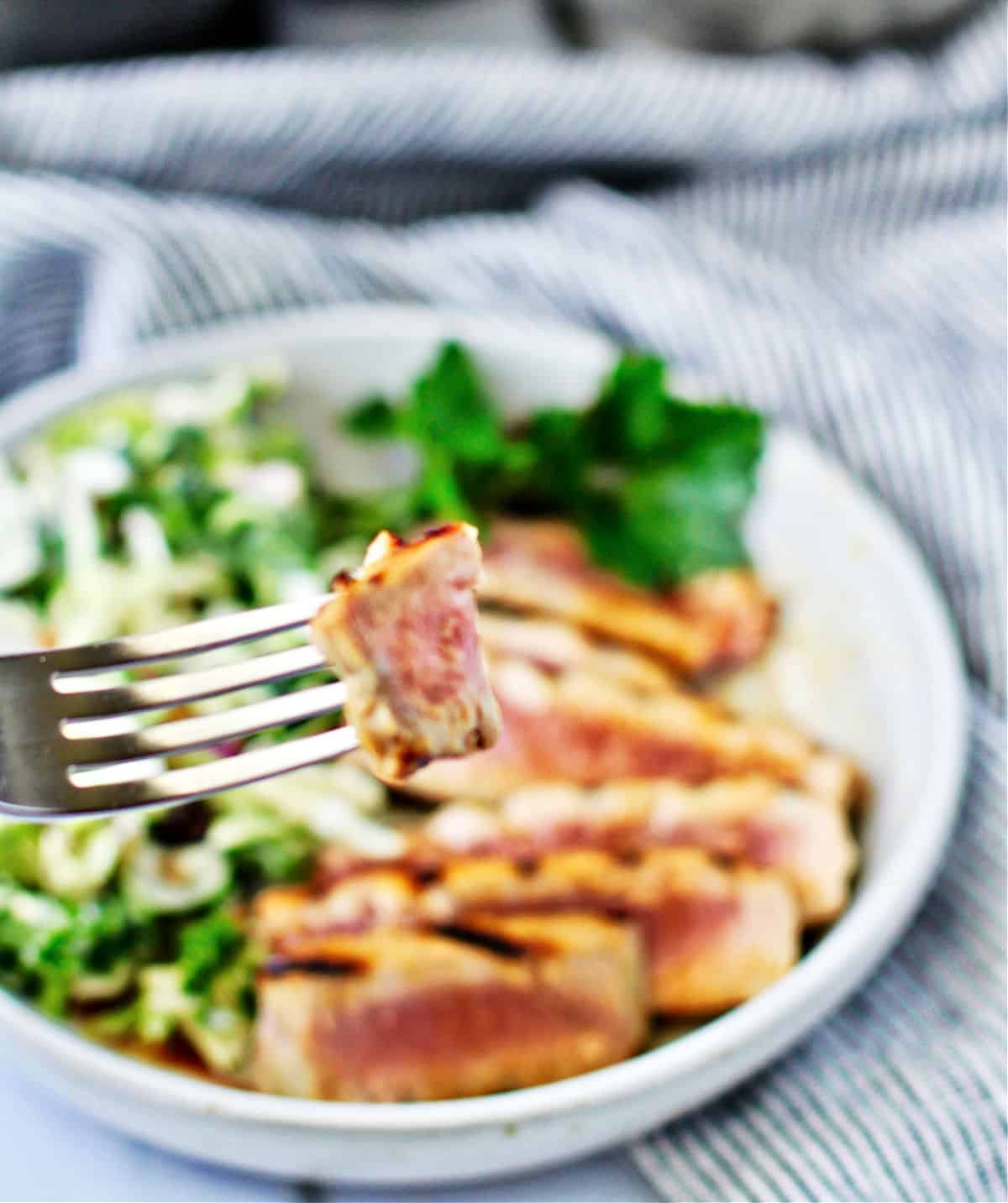Grilled Tuna Steaks with Honey Vinaigrette bite on a fork.