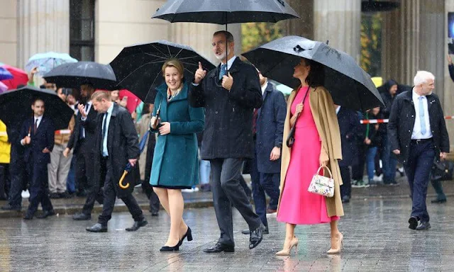 Carolina Herrera double-faced camel beige wool coat. Moises Nieto fuchsia dress. Furla 1927 floral pattern mini handbag