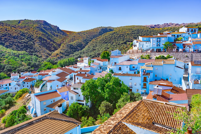 Casas de pueblo pintadas de azul y las montañas al fondo