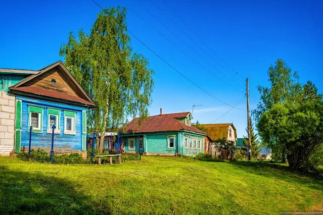 Лавочка на пригорке у двух деревенских домов