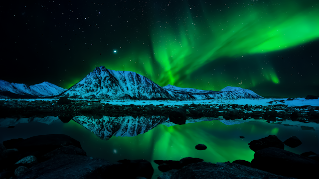 Experience the beauty of the natural world with this stunning 4K desktop wallpaper featuring the aurora borealis, also known as the northern lights.