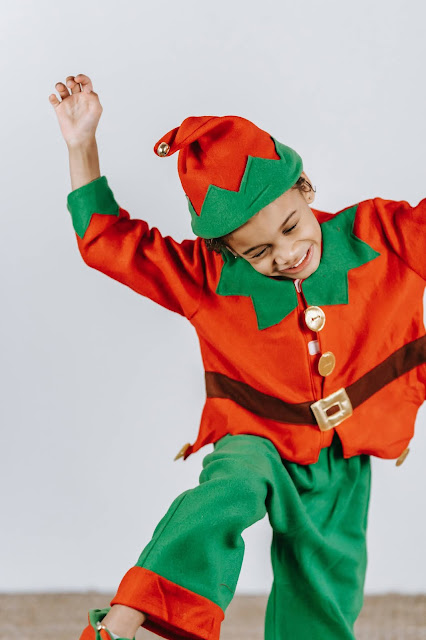 Niño saltando disfrazado de elfo de navidad