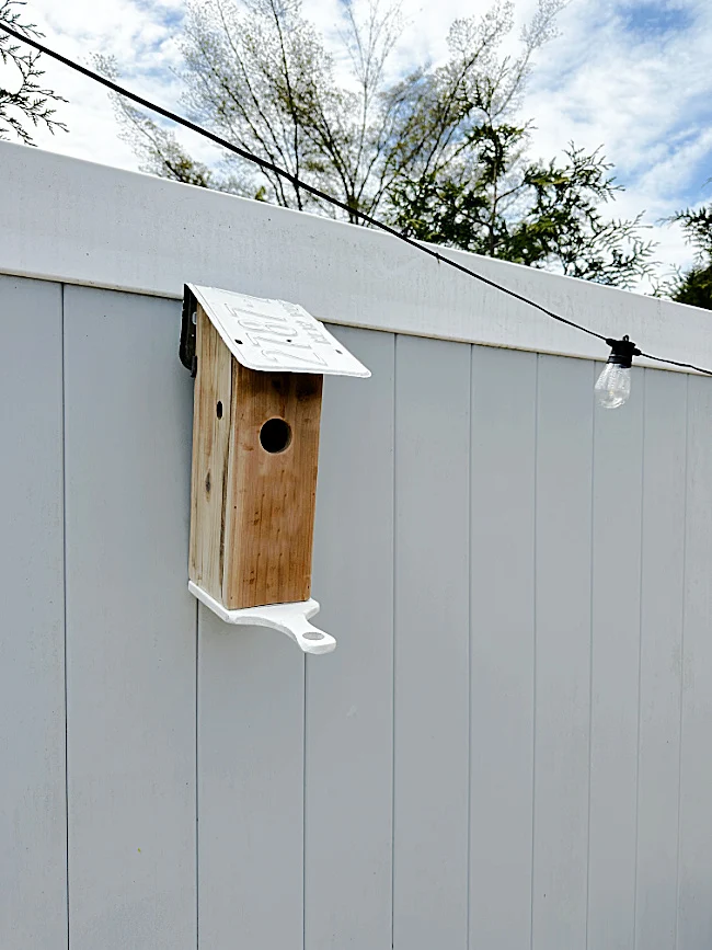 birdhouse and lights on fence