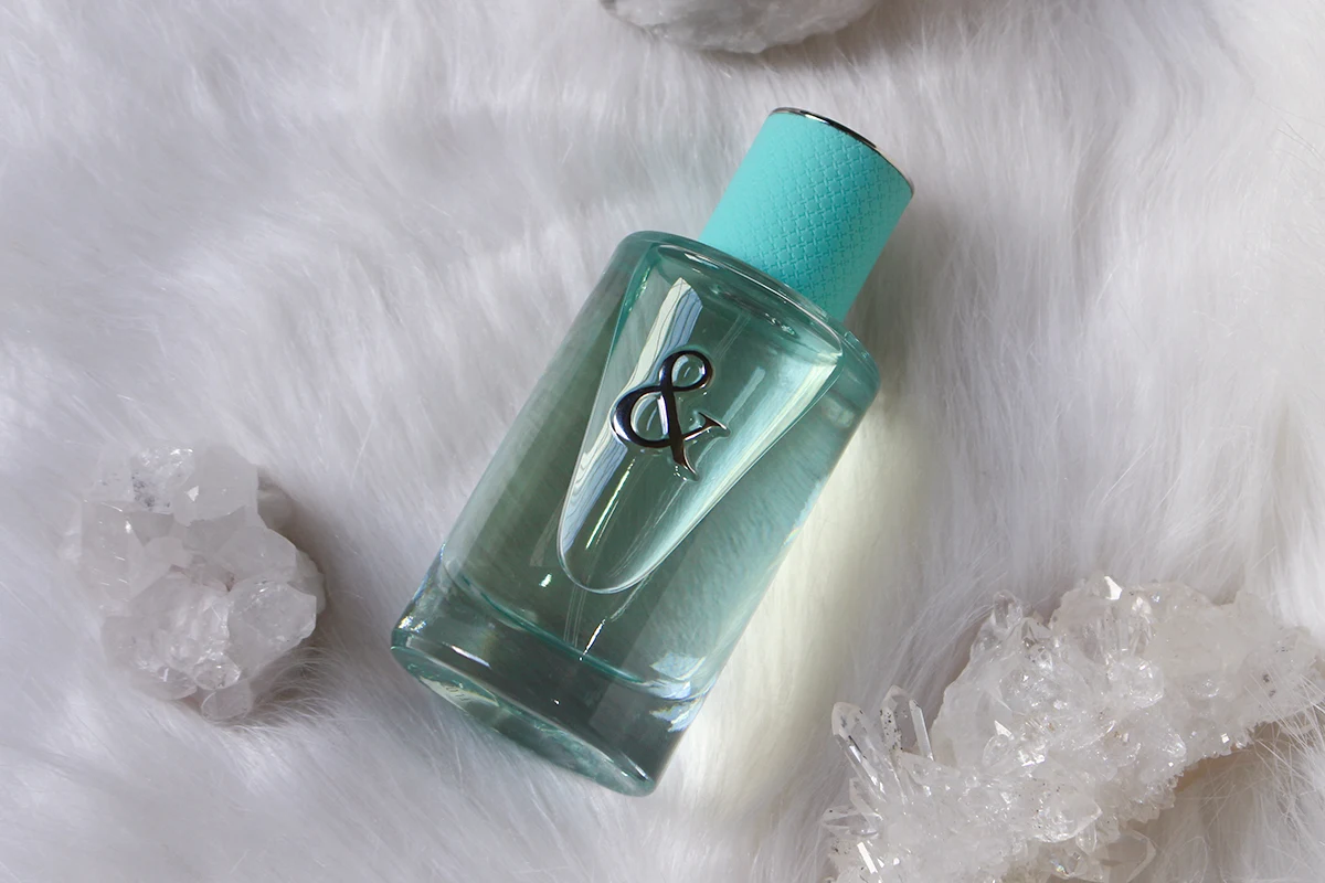 close-up studio shot of Tiffany & Co Love For Her Perfume tube on a white background surrounded by raw crystals