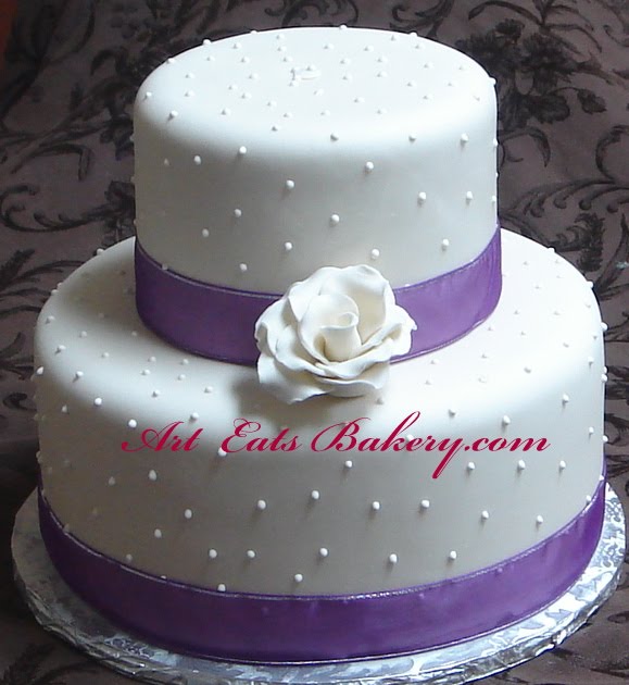 Two tier ivory wedding cake with royal icing dots and hand crafted sugar 