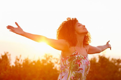 woman with arms open in the sunset