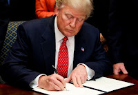 Trump signs document (Credit: Photograph Pool | Getty) Click to Enlarge.