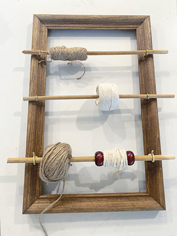 frame with sticks and spools of twine