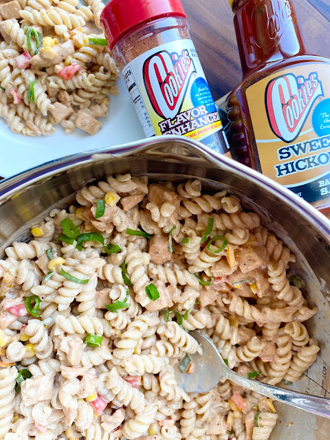 Bowl of pasta salad next to plated serving with Cookies BBQ bottle of sauce