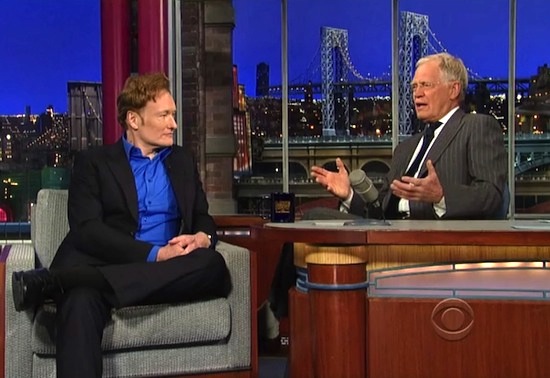 Conan O'Brien in a guest chair, David Letterman gesturing with hands apart while seated behind his desk