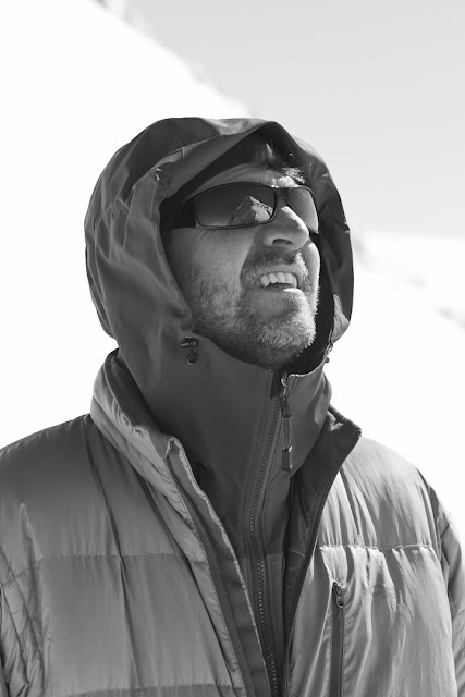 Man looks up at The President mountain, which reflects in his glasses.