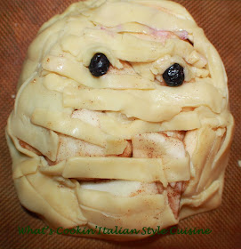 this is pie dough transformed into a mummy apple galette. This shows how to make a mummy using pie crust and its filled with apple pie filling. The eyes are made with blueberries and  a Halloween treat.