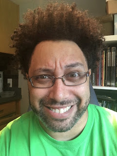 A dark skinned man in a green shirt.