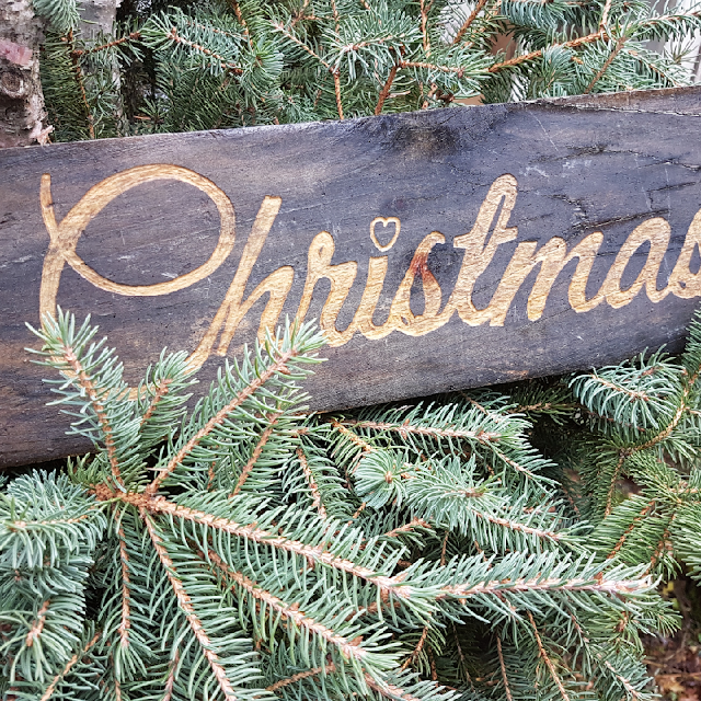 wooden christmas sign with spruce evergreens