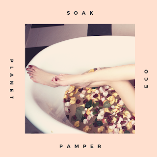 a womans white legs in a bathtub with rose petals, her toenails are painted red